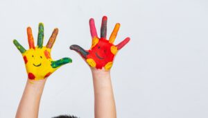 Mãos infantis pintadas com várias cores
