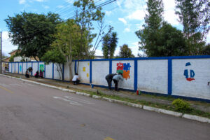 grupos de estudantes estão pintando o muro da instituição
